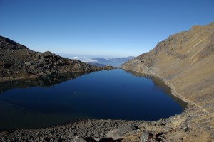 Der groesste See von Gosaikunda glaenzt in der Morgensonne wie ein Spiegel